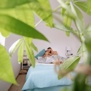 A photograph of peaking through plants to see a couple in bed to represent not being introduced to friends and family