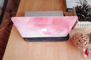 My photograph of my Pink and white covered MacBook Pro on a wooden desk