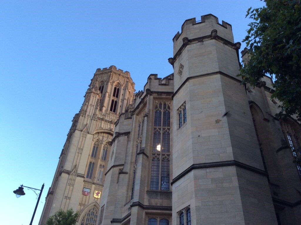 A ground photgraphy of Bristol Cathedral in Bristol city set against a bright blue sky.