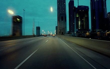 Moving image of cars and buses driving over an overpass/flyover, driving past modern tall buildings to depict the 3rd house in astrology and transportation