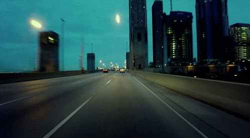 Moving image of cars and buses driving over an overpass/flyover, driving past modern tall buildings to depict the 3rd house in astrology and transportation