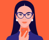 A woman with dark hair and a small center parting wearing indigo glasses and white earrings, indigo turtleneck holds a orange cell phone the matched the colour of the background. The woman depicts how to spot an Aries woman