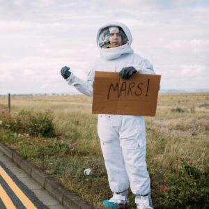 A photograph of Person in a space suit. Costume Hitchhiking to mars on the roadside