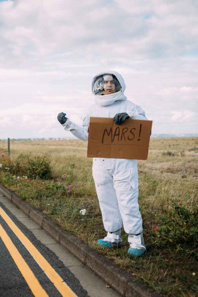 A photograph of Person in a space suit. Costume Hitchhiking to mars on the roadside