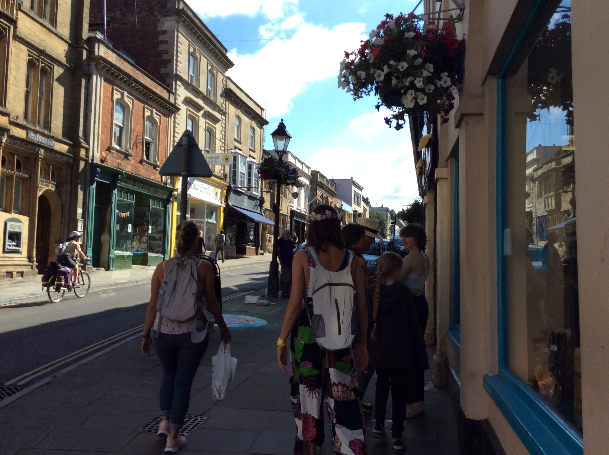 My photograph of a woman wearing a flower crown as she walks through Glastonbury town